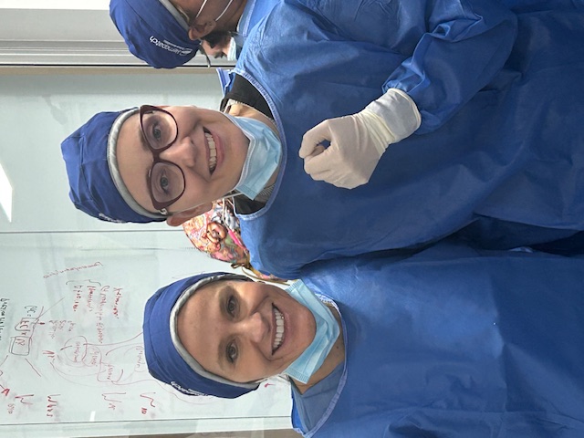 Two surgeons dressed in OR gowns and masks